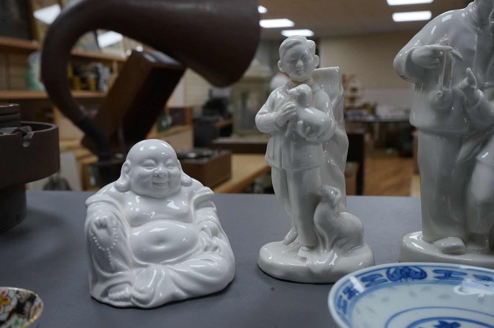 Four Chinese blanc de chine figures and two blue and white dishes and a model of a garlic bulb. Tallest figure 17.5cm.